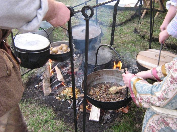 Gusseiserne Töpfe hängen über dem Lagerfeuer