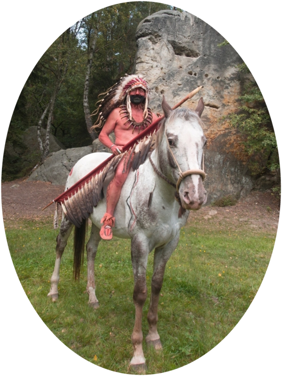 Darsteller der Plains-Stämme mit Federhaube zu Pferd vor einem Felsen